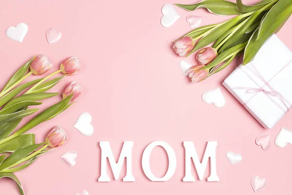 Mensaje del día de las madres con tulipanes y regalo sobre fondo rosa. Copiar espacio, plano laico, vista superior. Concepto del día de la madre
. - foto de stock