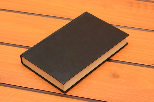 Black book mockup on wooden table, study theme