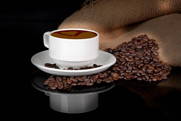 Rostade brun kaffebönor med vit kopp — Stockfoto