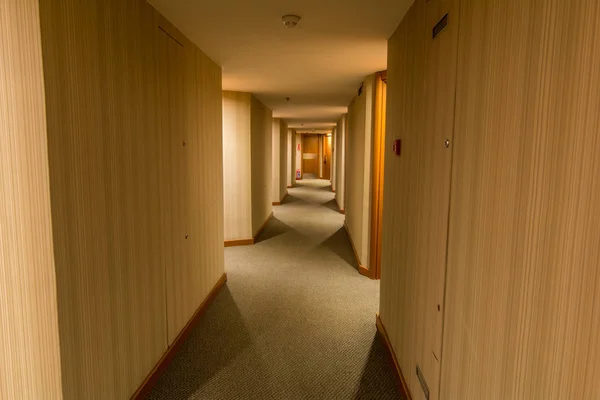 A hotel hallway with wooden texture wall