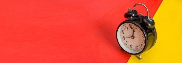 Relógio de mesa preto no modelo de banner amarelo e vermelho — Fotografia de Stock