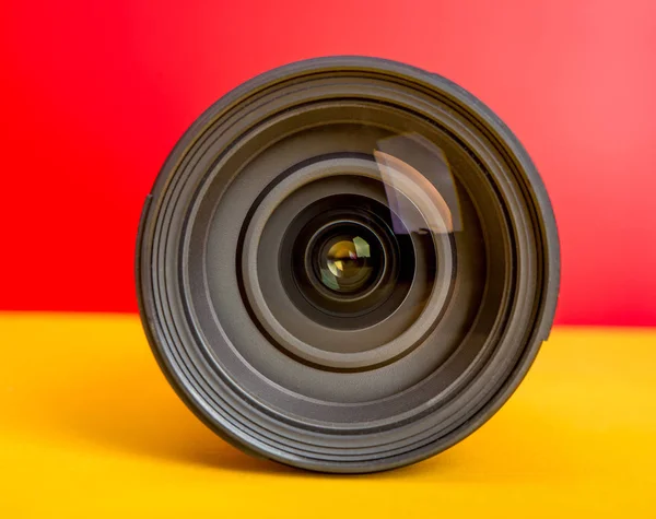 Professional Camera Lens on red and yellow background template