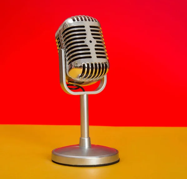 Detailní záběr zvuková koncepce Retro mikrofon s červeným a žlutým pozadím — Stock fotografie