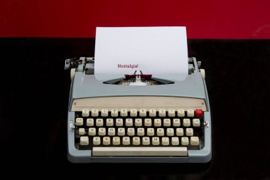 Kağıt üzerinde nostalji metni ve siyah arka planda eski bir daktilo.