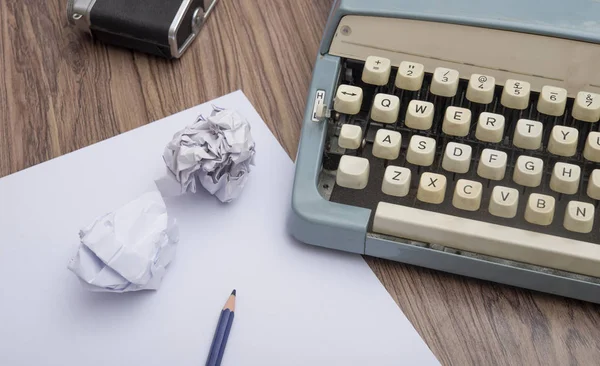 Ancienne machine à écrire manuelle sur fond en bois et papiers froissés — Photo