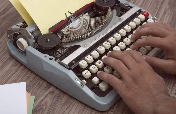 Ruky psaní na starý psací stroj s dřevěným pozadím — Stock fotografie