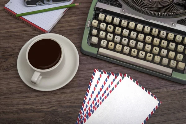 Typewriter on the old wooden desk with coffee cup and note book top view — Stock Photo, Image