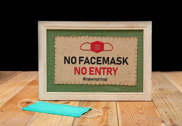 No Service without a face mask - new normal sign on wood table. Post pandemic life.