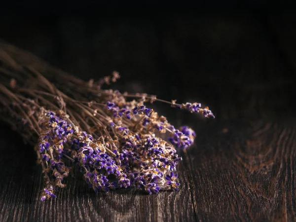 Bunch of lavender flowers on brown wooden table with copy space. Low key