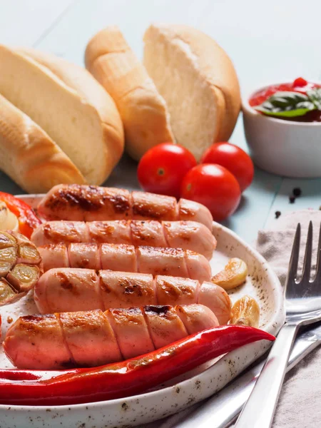 Close up view of chicken homemade sausages with buns bread. Grilled sausages and grilled vegetables in craft trendy plate. Home hotdogs. Vertical. — Stock Image Close View Chicken Homemade Sausages Buns Bread Grilled Sausages Grilled Stock Image