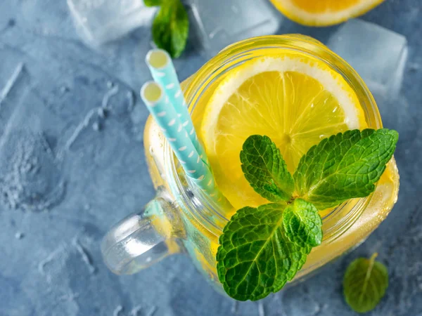 Lemonade with mint in mason jar on blue concrete background. Summer drink. Top view or flat lay. Copy space