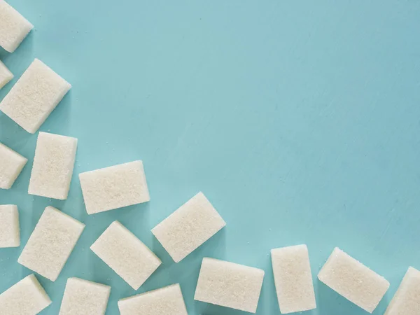 background of sugar cubes. White cube sugar on blue background. White sugar close up with copy space