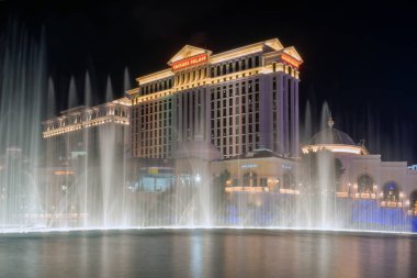 Las Vegas, Nevada/Amerika Birleşik Devletleri-Nisan 9,2018: Las Vegas Blvd s Las Vegas City gece Caesar Palace Las Vegas otel ve casino önünde Çeşme dans gösterisi.
