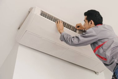 Klima repairers duvarda asılı denetleme ve onarma hava vardır.