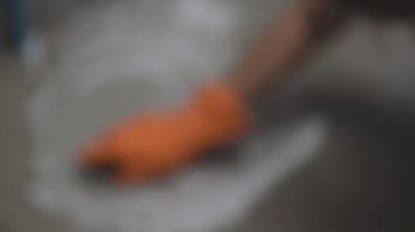 Turuncu lastik eldiven giyen kadın eli bodur Seramik Zemin Temizleme dönüştürmek için kullanılır.