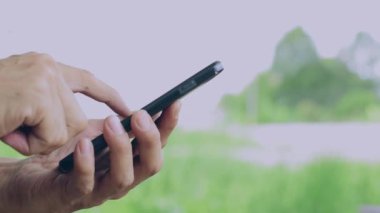 Bilgi veya iş bağlantıları aramak için akıllı telefon kullanarak bir adamın elini yakın.