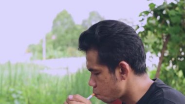 Asyalı erkekler bazı ülkelerde yasadışı parkta sigara içiyor.