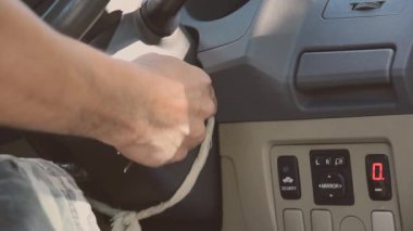 Bir adamın elini arabanın motoru, ulaşımı ve sigorta endüstrisi kavramlarını çalıştıracak anahtarla kapatın..