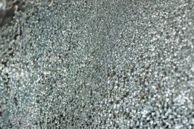 Garajdaki sigorta tazminatına giden yolda meydana gelen bir kazanın yol açtığı cam kırıklarının yakın çekim yüzeyi..