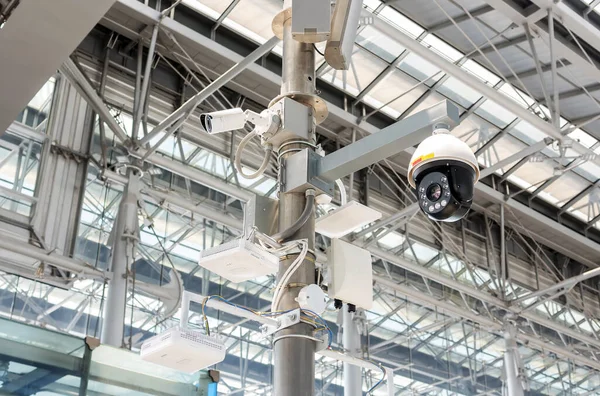 CCTV cameras, wireless signal distribution equipment and speakers mounted on poles inside the building.