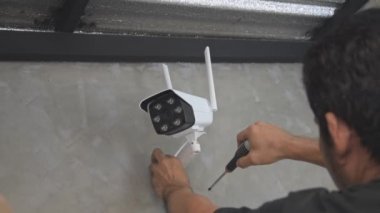 Teknisyenler güvenlik amacıyla evin duvarlarına kablosuz güvenlik kameraları yerleştiriyor..