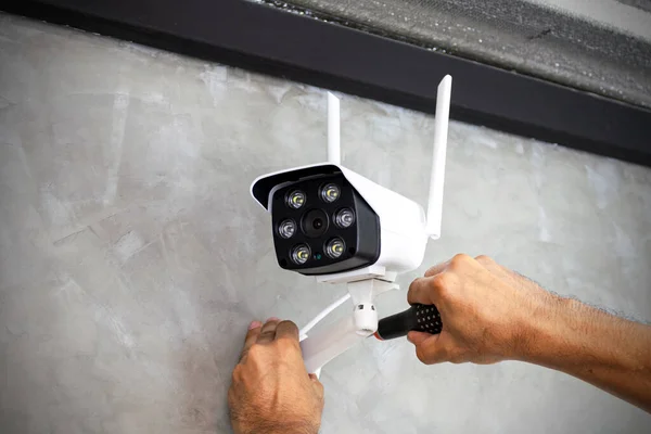 Teknisyenler güvenlik amacıyla evin duvarlarına kablosuz güvenlik kameraları yerleştiriyor..