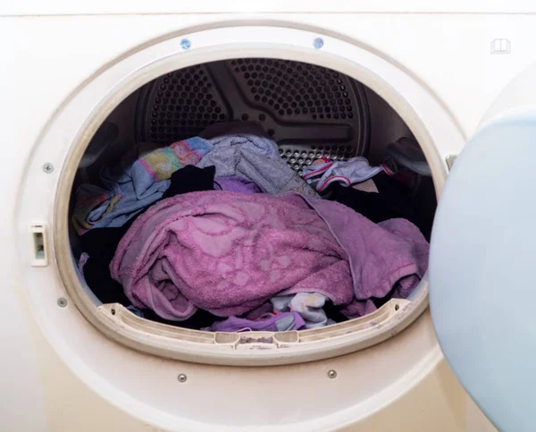 Washing machine porthole in the foreground with laundry inside