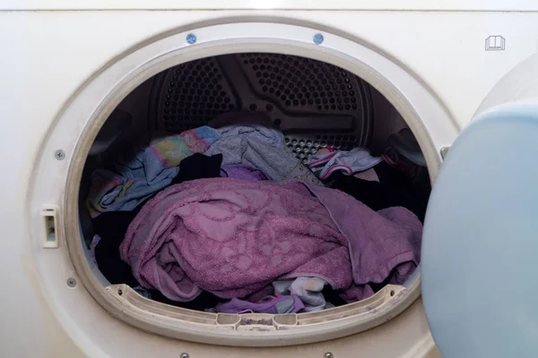 Washing machine porthole in the foreground with laundry inside