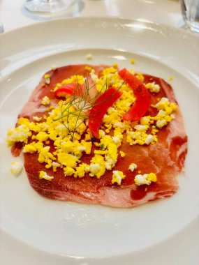 Kızarmış yumurta ve sotelenmiş dolmalık biberle servis edilen nefis bresaola.