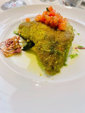 Taze vişneli domates ve beyaz bir tabakta dilimlenmiş soğanla servis edilen pirzola filetosu.