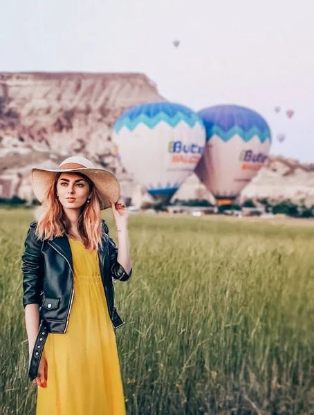 Sıcak hava balonları arka planda Kapadokya'da güzel bir genç kadın