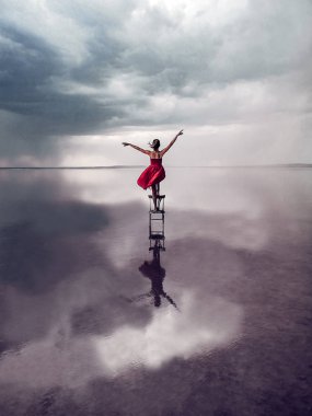 Kadın kırmızı elbise ayakta yağmur altında. Türkiye'de Tuz Gölü Tuz.