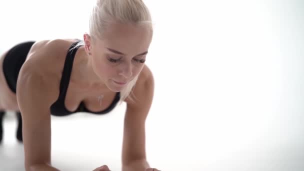 Sportig tjej gör planka motion och skrattar — Stockvideo