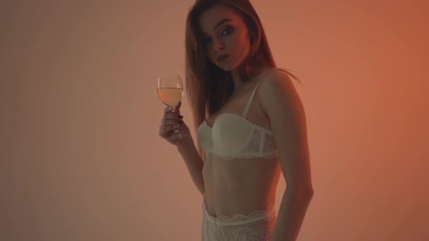 Dívka v bílém prádle pije bílé víno. Slow motion 60fps — Stock video