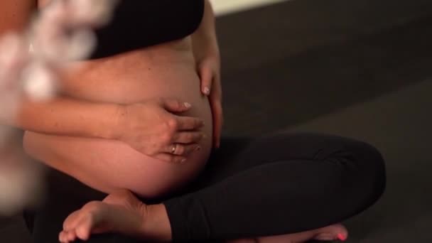 Pregnant brunette girl doing yoga. Authentic style with natural light and shadows. — Stock Video