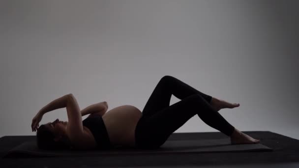 Schwangere Brünette beim Yoga. authentischer Stil mit natürlichem Licht und Schatten. — Stockvideo