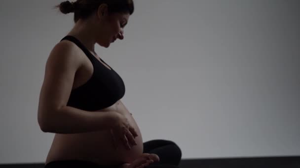 Chica morena embarazada haciendo yoga. Estilo auténtico con luz natural y sombras . — Vídeo de stock