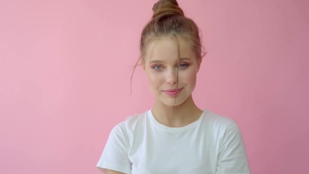 Flicka i studion på en rosa bakgrund. Reklam, Hårprodukter, skönhetssalong, kosmetika, kläder. Mode, butik. Rosa. — Stockvideo