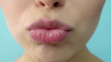 Açık mavi arka plan kameraya bakan mavi gri gözlü şehvetli güzel genç kadın portresi.