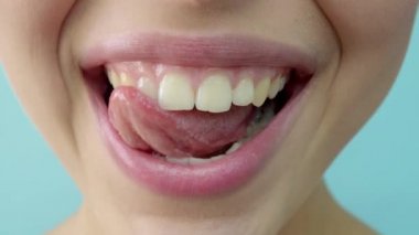 Açık mavi arka plan kameraya bakan mavi gri gözlü şehvetli güzel genç kadın portresi.