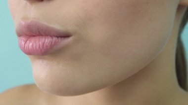 Açık mavi arka plan kameraya bakan mavi gri gözlü şehvetli güzel genç kadın portresi.