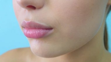 Açık mavi arka plan kameraya bakan mavi gri gözlü şehvetli güzel genç kadın portresi.