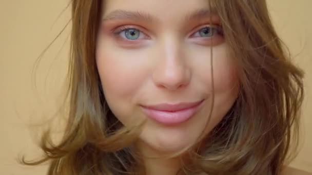 Крупним планом портрет молодої вовни позує на камеру з видутим волоссям на сірому — стокове відео