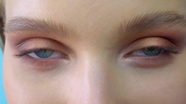 Bliska portret piękna Młoda piękna womans oczy, uśmiechnięty patrząc na kamerę. 4 k. niebieskie oczy kobiety twarz, piękna kobieta dziewczyna portret modelu, dziewczyny oko. otwarcie jej niebieskie oczy — Wideo stockowe