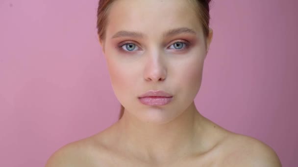 Девушка на студийном фоне, концепция красоты, на розовом фоне — стоковое видео