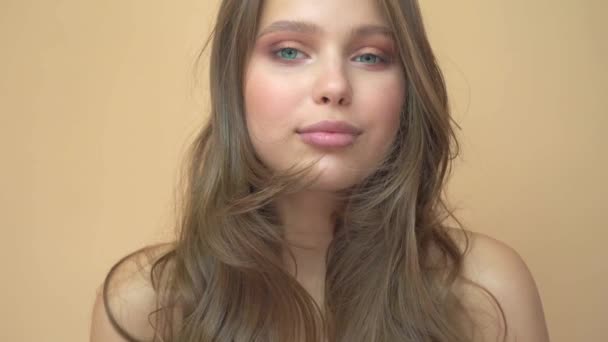 Close-up retrato de jovem wooman posando para uma câmera com cabelos estourados no cinza — Vídeo de Stock