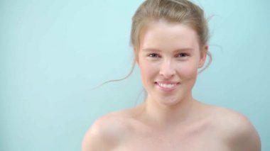 Mavi arka plan üzerinden kameraya bakan gizemli zencefilli kadının yakından görünümü