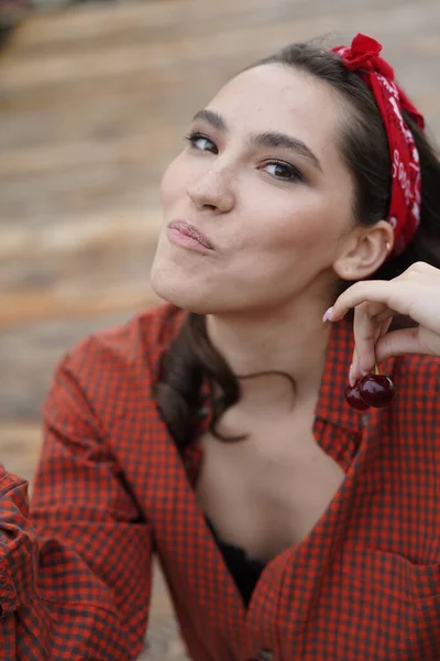 Kiraz yiyen güzel kadınların yakın plan portresi. Bir kadının ağzına nişan al. Açık havada.