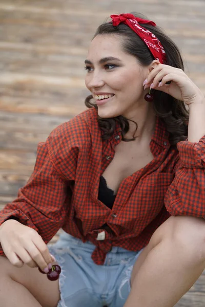 Kiraz yiyen güzel kadınların yakın plan portresi. Bir kadının ağzına nişan al. Açık havada.