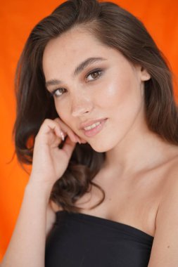 Genç kadın beyaz arka planda gözlerini aç. Stüdyoda kameraya bakan gülümseyen kıza yaklaş. Kıvırcık saçlı manken yüzü gülümsüyor. Neşeli kızın portresi, açık gözler. Kadın doğası güzelliği